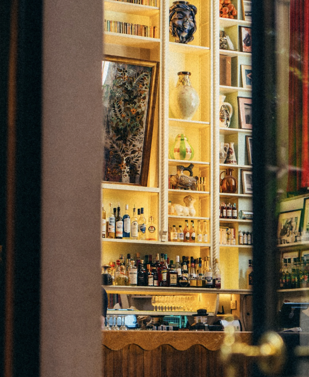 Bar illuminato con scaffali di bottiglie e ceramiche