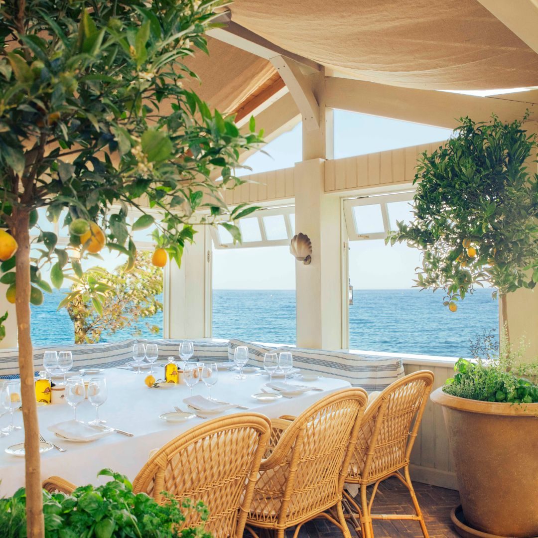 Loulou Pirate, terrazza sul mare con limoni e sedie in rattan