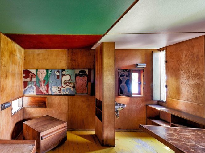 Interno del Cabanon di Le Corbusier con murale e legno